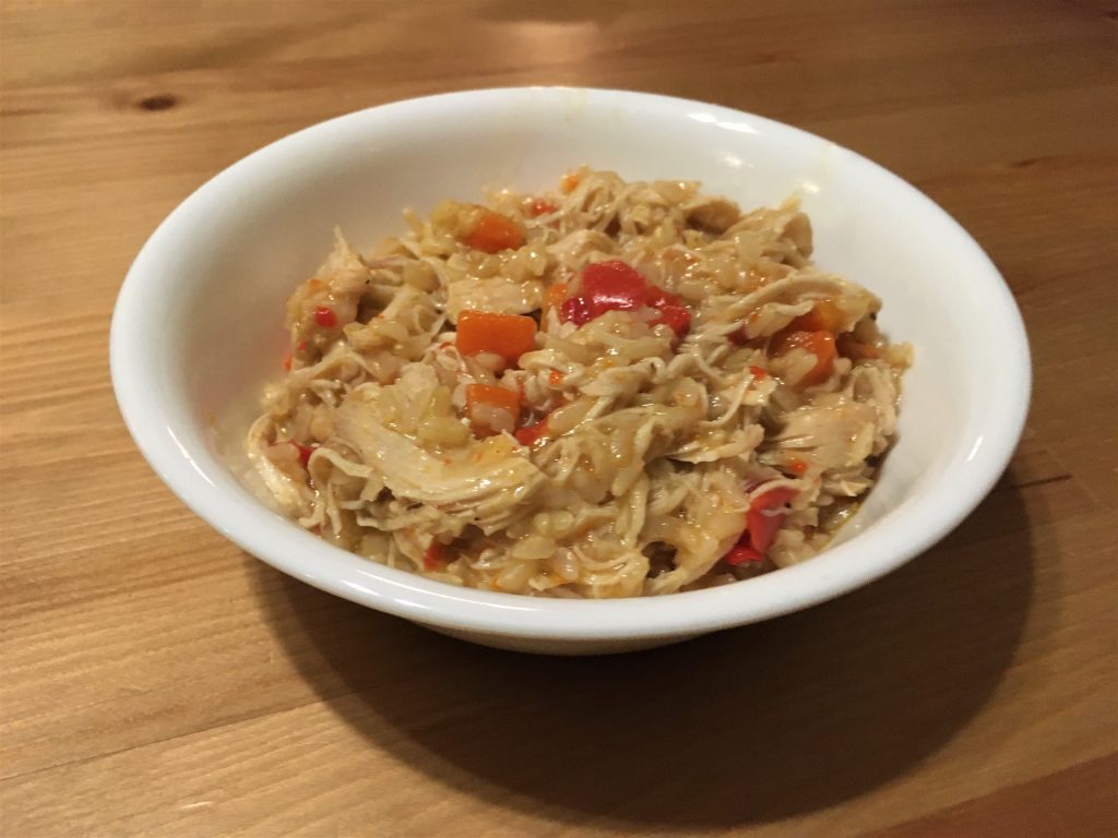 bowl full of chicken and rice with peppers and carrots
