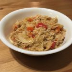 bowl of rice and chicken with diced red peppers and carrots