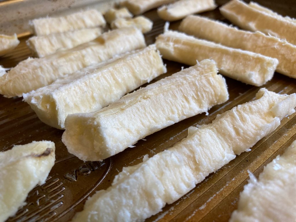Frozen banana strips on a sheet pan