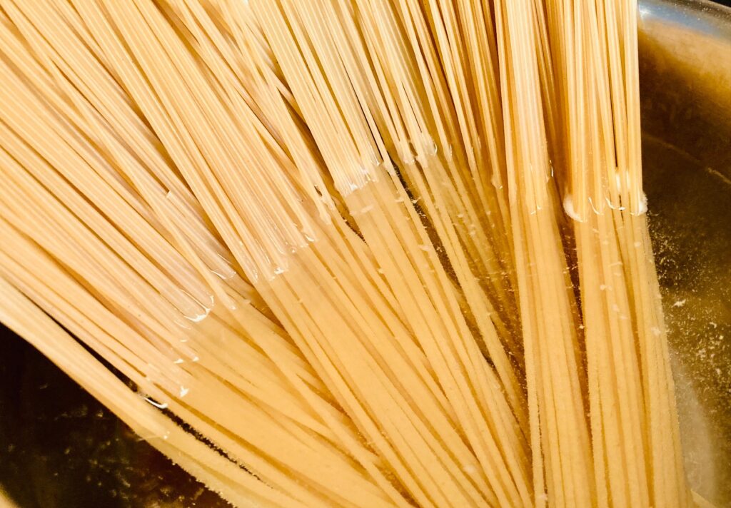 uncooked spaghetti in pot of water