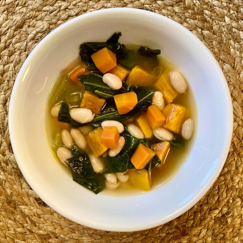 bowl of white beans, greens and sweet potato soup